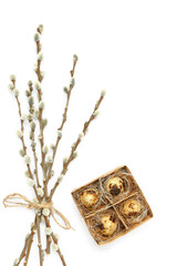 Box with Easter quail eggs and willow branches on white background