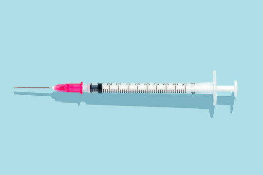 injection syringes. Top view and blue background. Disposable medical syringes with a needle. Applicable to vaccine injection. Single use syringe. Space for copy. Jeringuilla