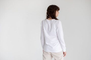 Rear view of a young woman with curly hair wearing a long sleeve t-shirt. Mock-up.