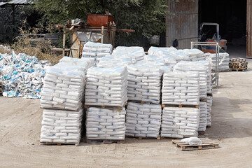 bags of gypsum on pallets in the yard of the warehouse - obrazy, fototapety, plakaty