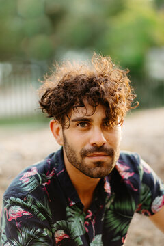 Portrait of a young guy with a beard and a flamingo shirt.