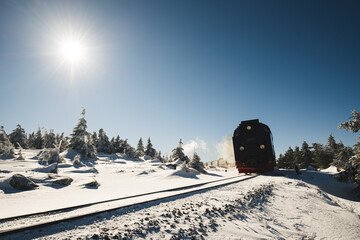 Dampflok Zug fährt durch eine verschneite Winterlandschaft mit Schnee auf dem Brocken in...