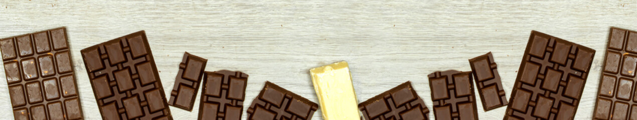 banner of milk and black, white chocolate bars on wood table