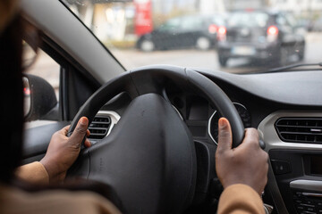 hands of driver on steering wheel, black woman driving