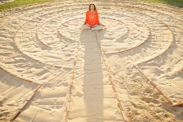 Woman sitting in the middle of a meditation labyrinth