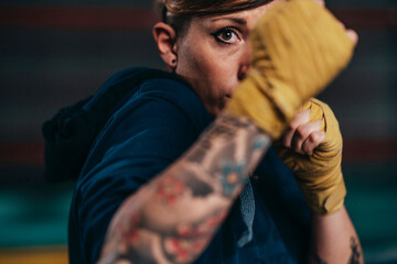 Serious motivated woman boxing in gym