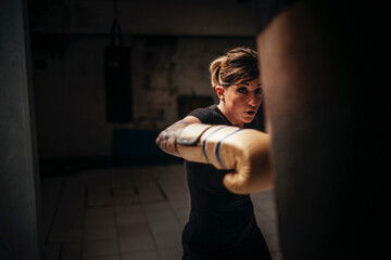 Focused strong woman boxing in gloves