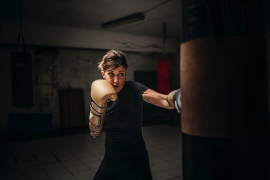 Focused strong woman boxing in gloves