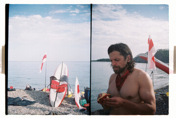 Man near kayak on seashore in summer