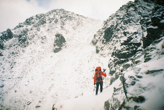 Hiker with backpack standing on snowy slope