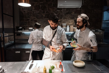 Male cooks preparing ingredients and speaking