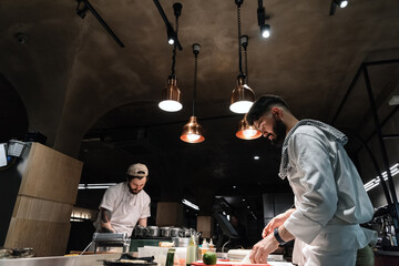 Busy male cooks in restaurant kitchen