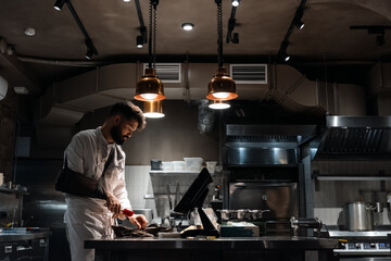 Chef with broken arm working in dim kitchen