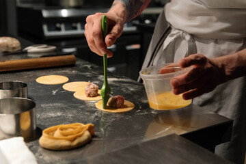 Crop cook smearing ravioli dough with yolk