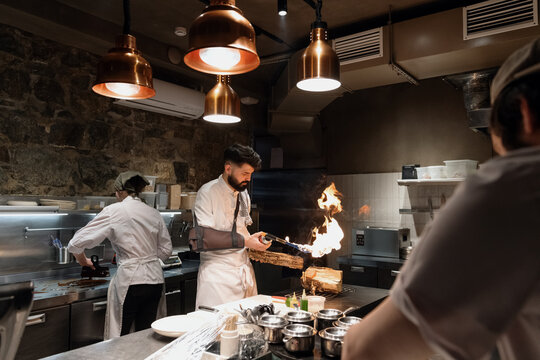 Man with gas burner working in restaurant kitchen