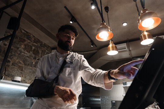Male chef confirming order on computer