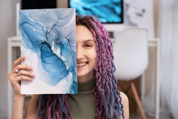 Cheerful woman showing abstract painting