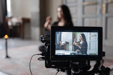 Camera shooting female meditating with singing bowl
