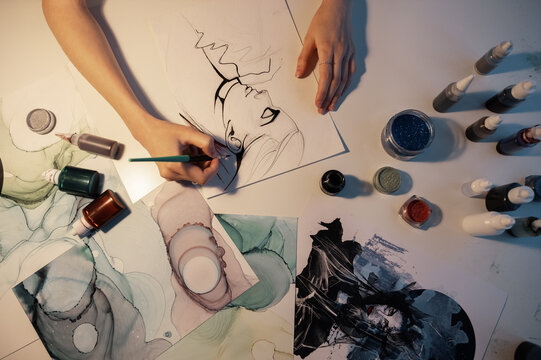 Crop woman drawing portrait on table