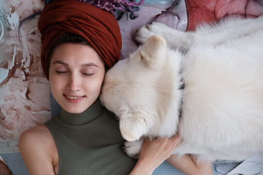 Dog touching face of creative female owner