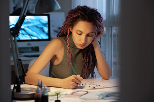 Female artist leaning on hand and drawing