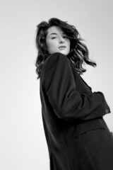 Naklejka premium black and white portrait of young stylish woman wearing wide pants and jacket