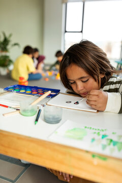 Boy painting with watercolors on a play date