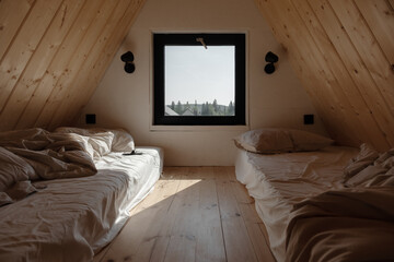 Unmade beds in wooden attic