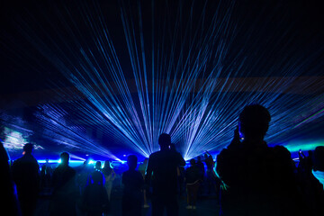 Laser lights and people silhouettes at city square. Celebrating city anniversary.