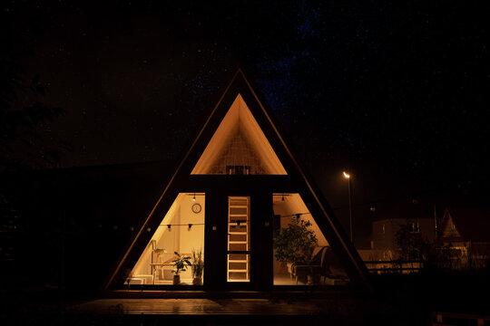 Illuminated triangle house at night