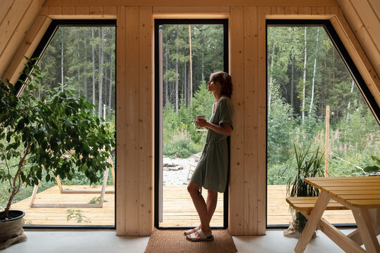Female resting in wooden house doorway in morning