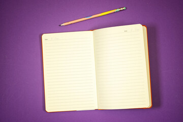 agenda book or notebook and pencils  isolated on purple background