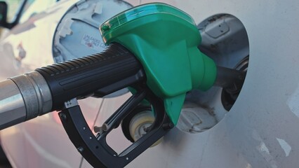 Gas Station Fuel Gasoline Pump Nozzle Pistol Inserted into Car Tank Filler Hatch - obrazy, fototapety, plakaty