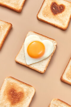 Closeup of toasts with burnt hearts and egg