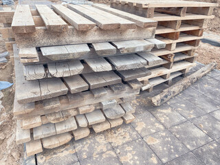 wooden pallets at the construction site. natural material for carrying heavy objects at a construction site. pallets for storage of building materials