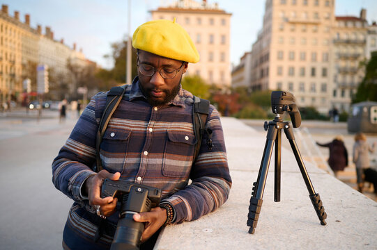black man on bridge looking at his camera 