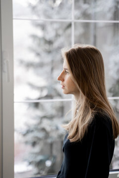 Thoughtful Woman Looking Through Window 