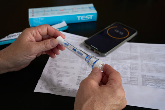 A woman holds a Covid-19 rapid antigen test showing a positive result
