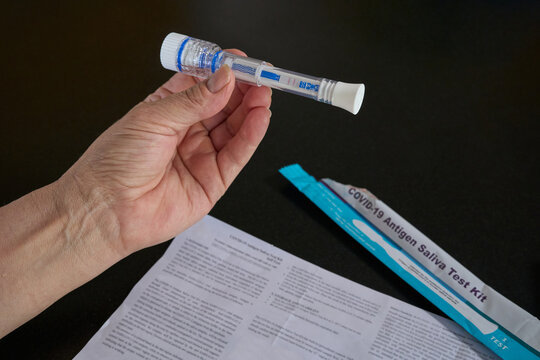 Person holding a rapid antigen test with a positive result