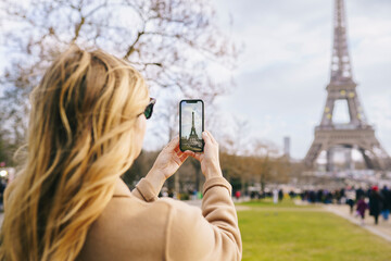 Woman taking picture of Eiffel tower