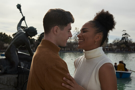 Couple looking at each other next to a lake park