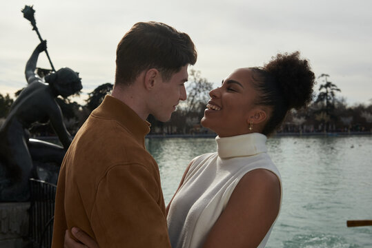 Couple looking at each other next to a lake park
