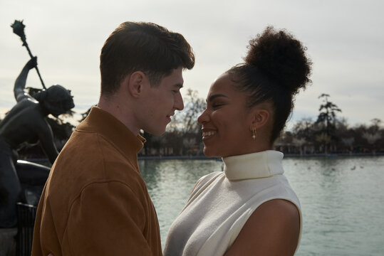Couple looking at each other next to a lake park