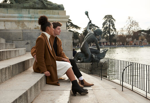 Multiracial couple sitting at a park stairs