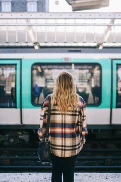 Anonymous woman standing against train