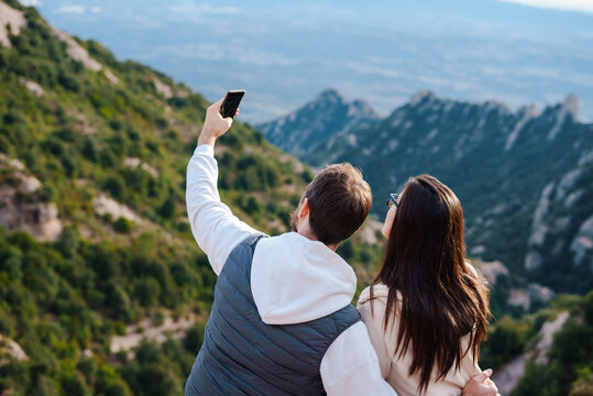 Couple making selfie on smartphone on mountain trip