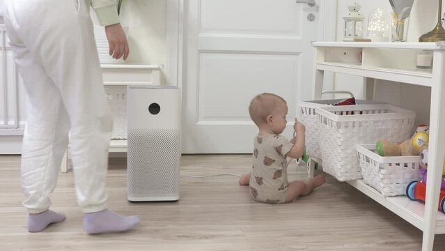 Toddler pulls the electric plug out of socket, 1 year old infant playing with electric wire on floor, risky objects around the house for baby. High quality 4k footage