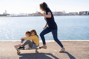 Mother and kids playing on embankment together