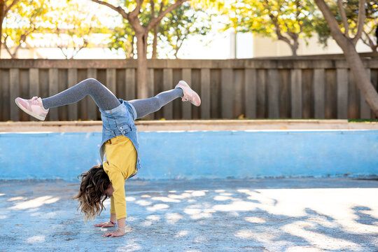 Girl showing handstand on street in city