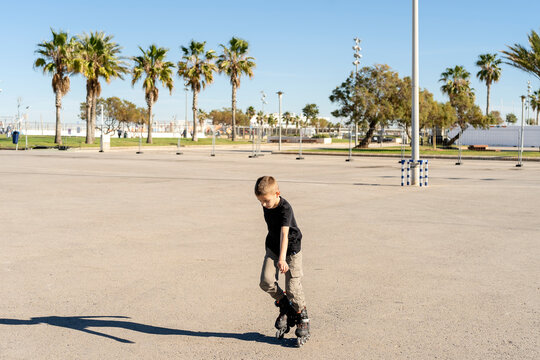 Child inline skating in city park on sunny day